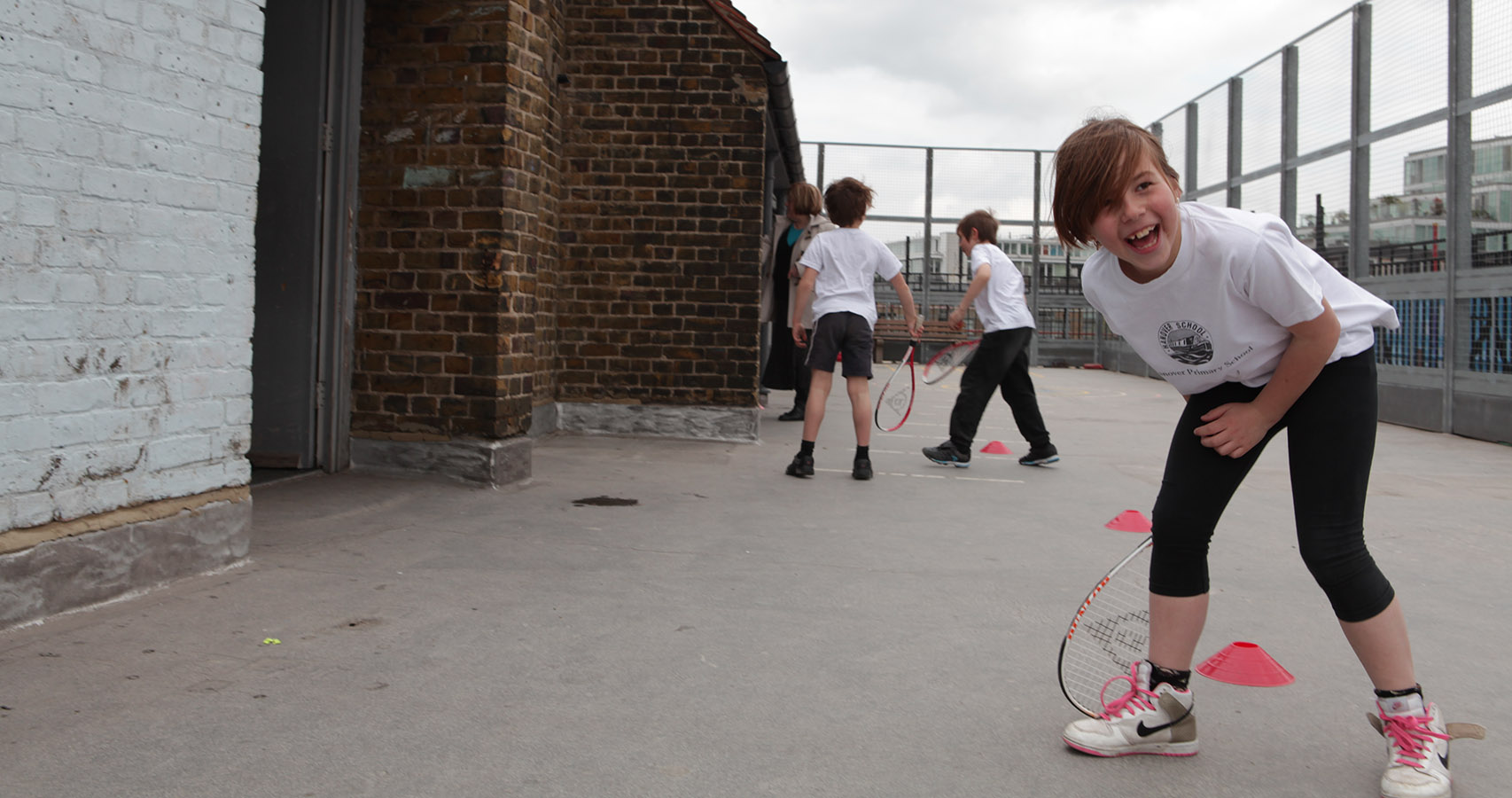 School children playing squash on a rooftop