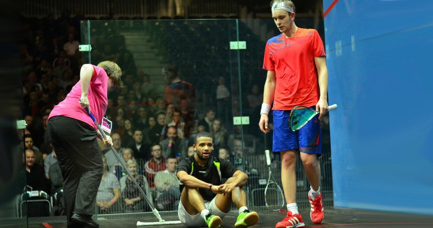 Volunteers sweeping the court during a James Willstrop match