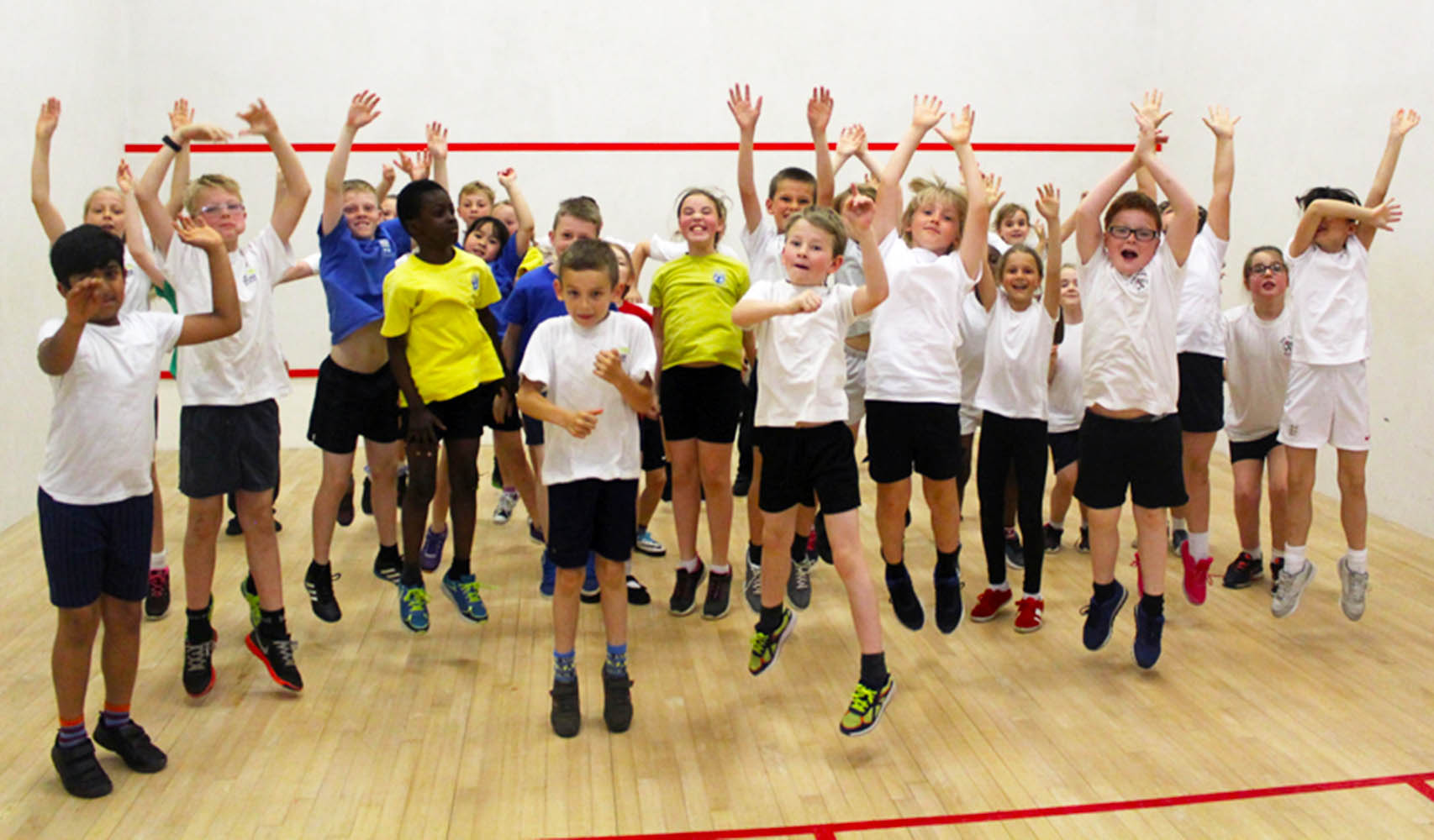 Group of school children cheering after a squash session