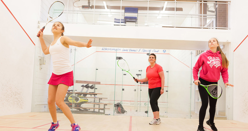 Three women playing squash