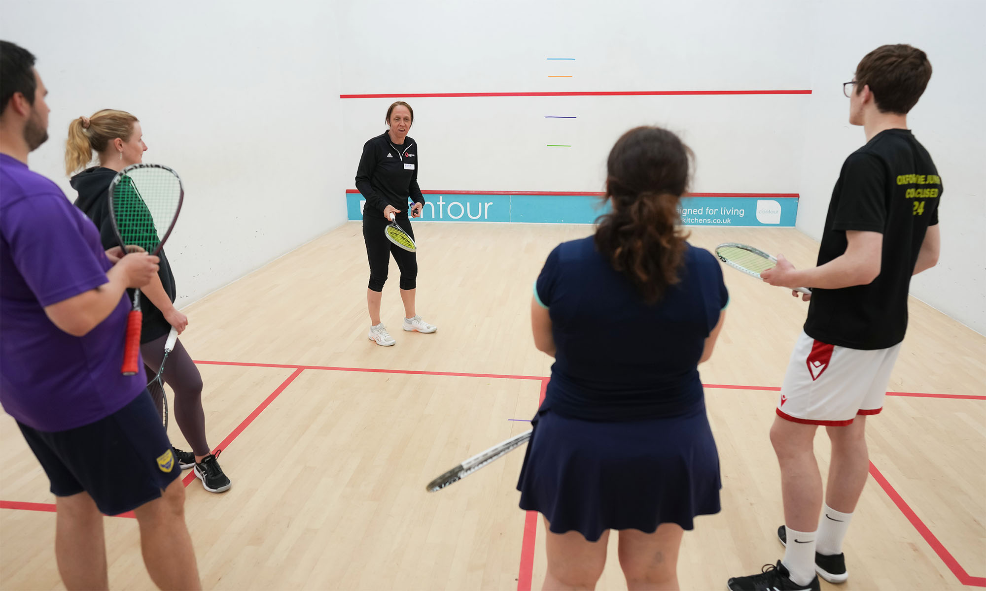 A tutor leading a squash course