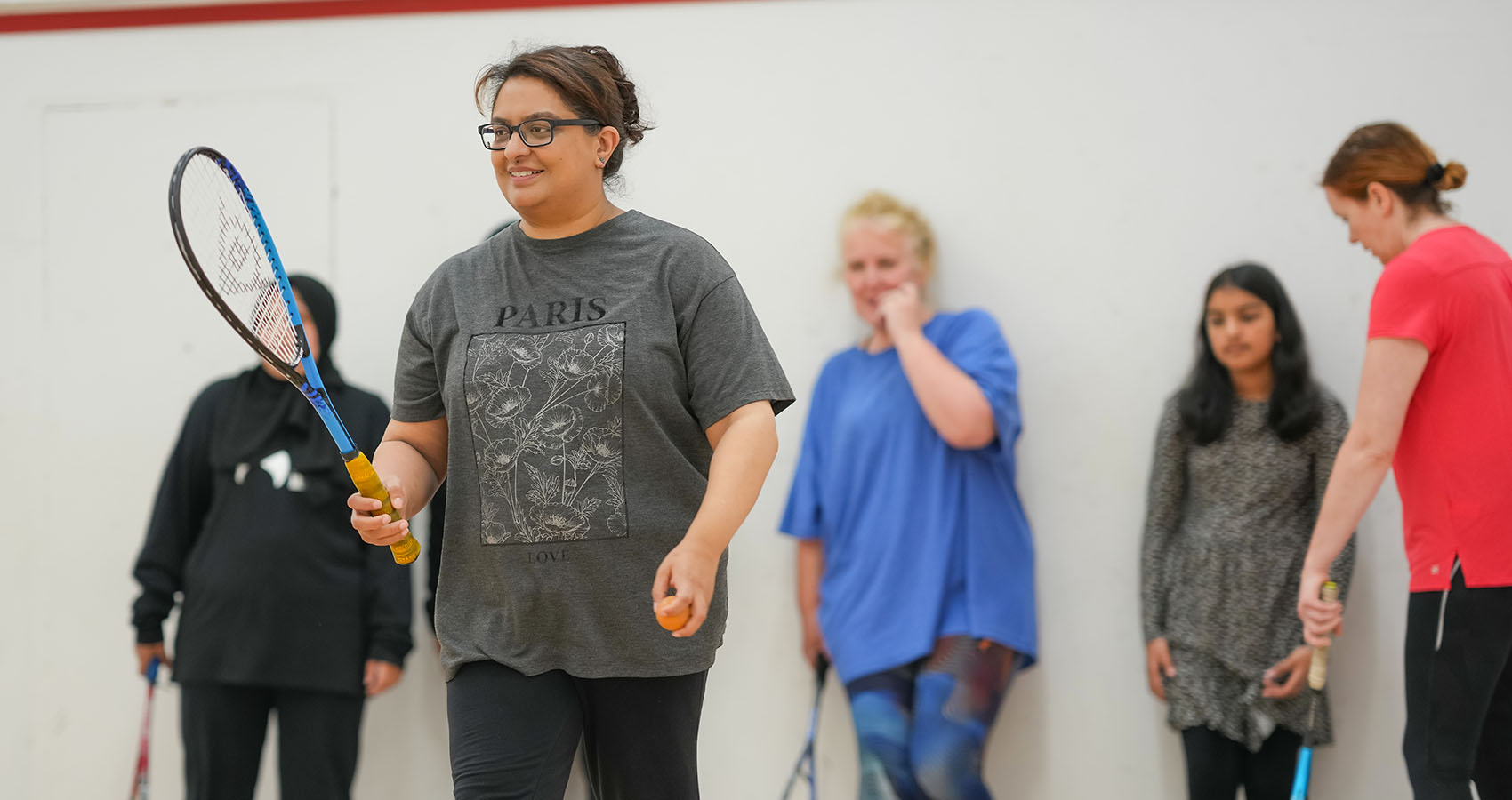 A group of women playing squash on court