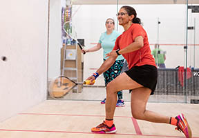 Two women on court playing squash