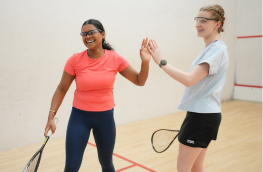 Two Girls High Fiving Playing Squash