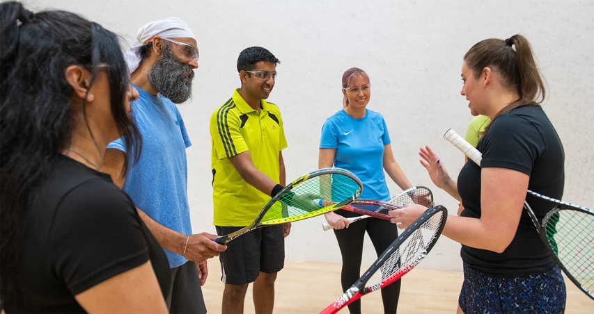 A squash coach leading a coaching session