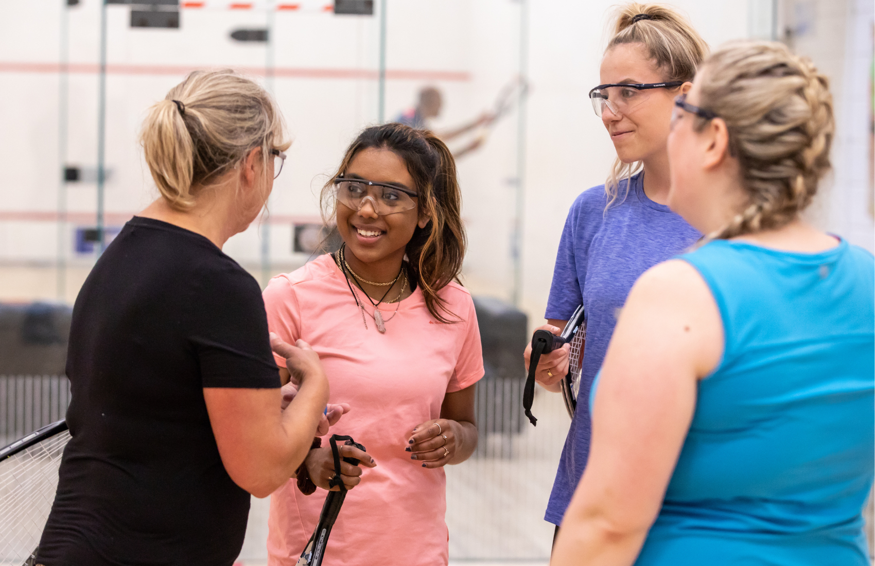 Women speaking together on a squash court