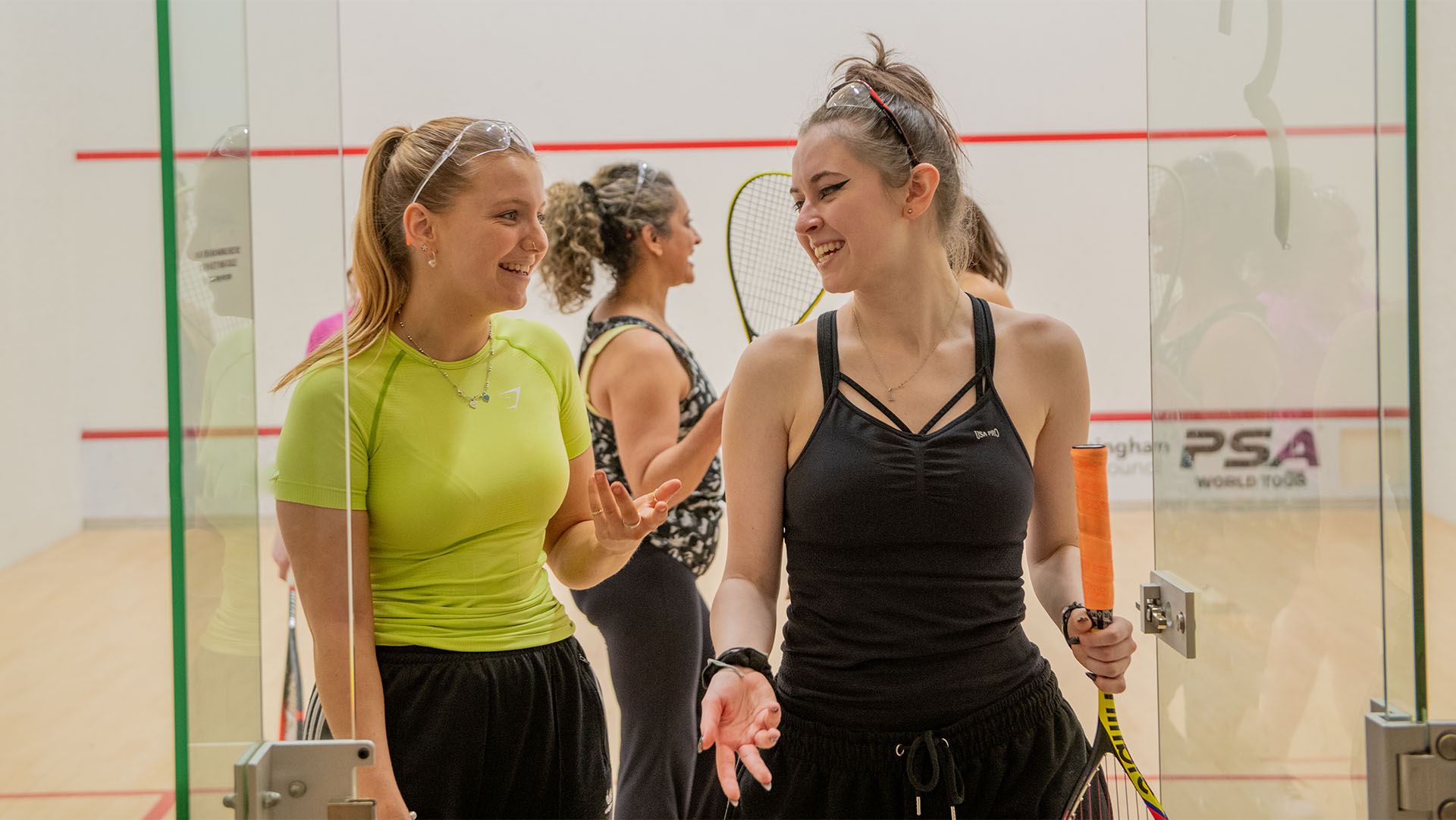 Women chatting and leaving a squash court