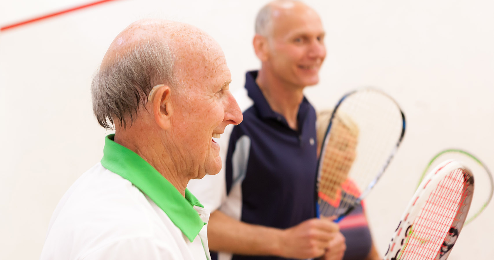Man with a hearing aid on a squash court